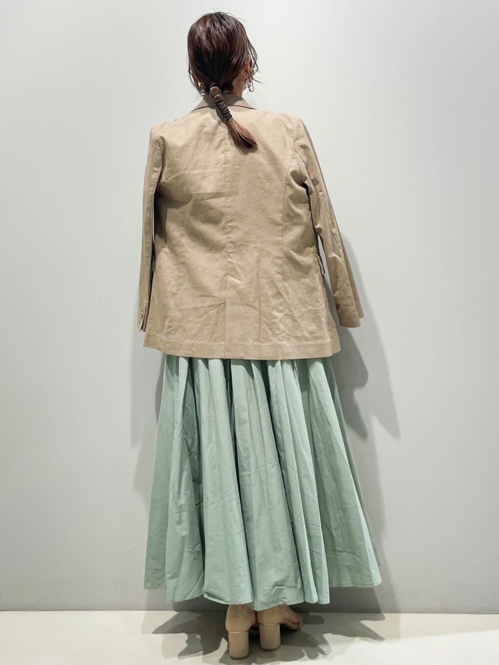 グリーン系のスカート、グリーン系のシャツ/ブラウス、ブラウン系のテーラードジャケットを着用したレディースの春コーディネートの3枚目の写真