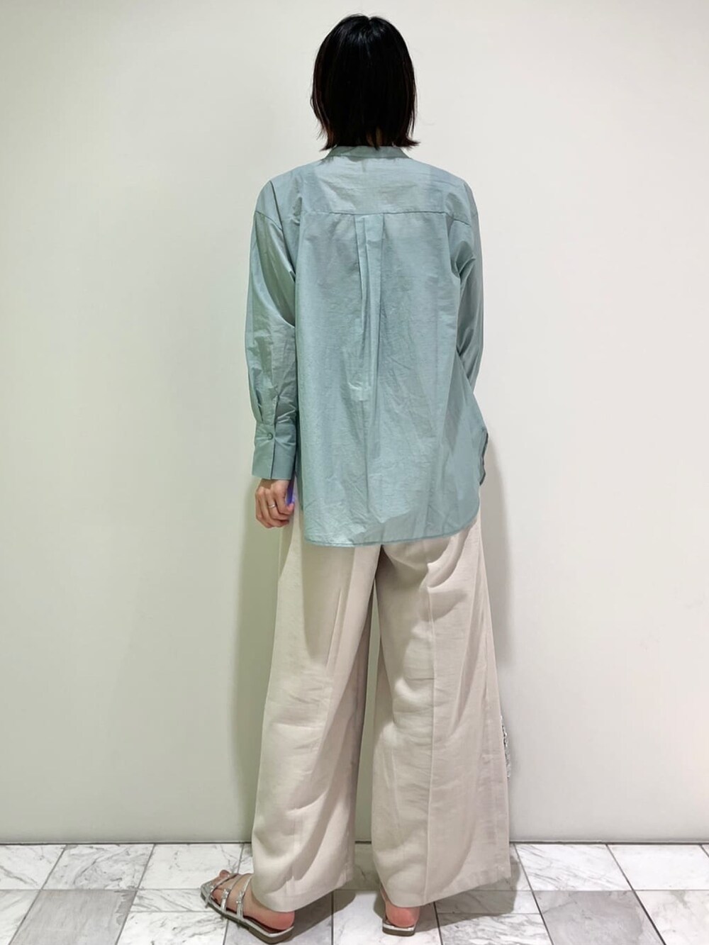 グリーン系のシャツ/ブラウス、ベージュ系のその他パンツ、シルバー系のトートバッグを着用したレディースの春コーディネートの4枚目の写真