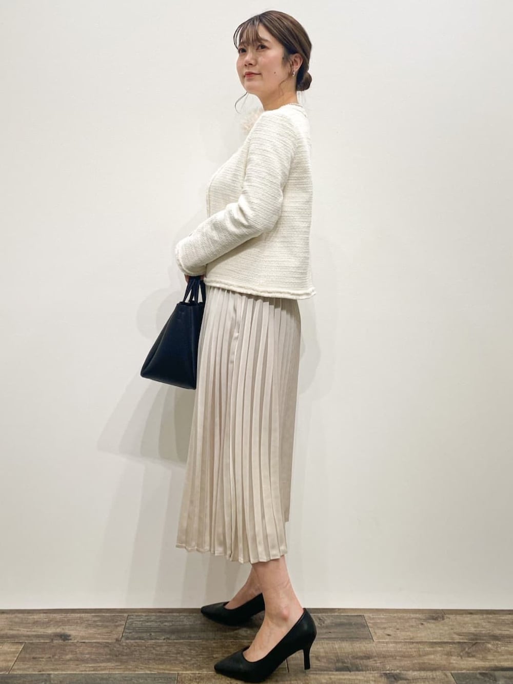 ホワイト系のノーカラージャケット、ベージュ系のワンピース、ブラック系のトートバッグを着用したレディースの冬コーディネートの2枚目の写真