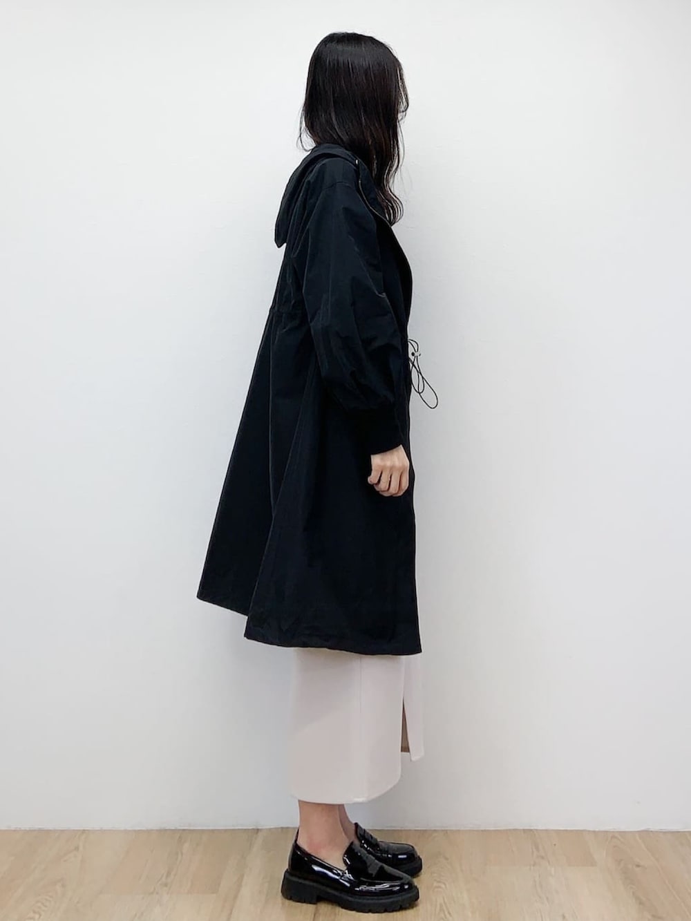 ブラック系のニット/セーター、ブラック系のその他アウター、ベージュ系のスカートを着用したレディースの春コーディネートの3枚目の写真