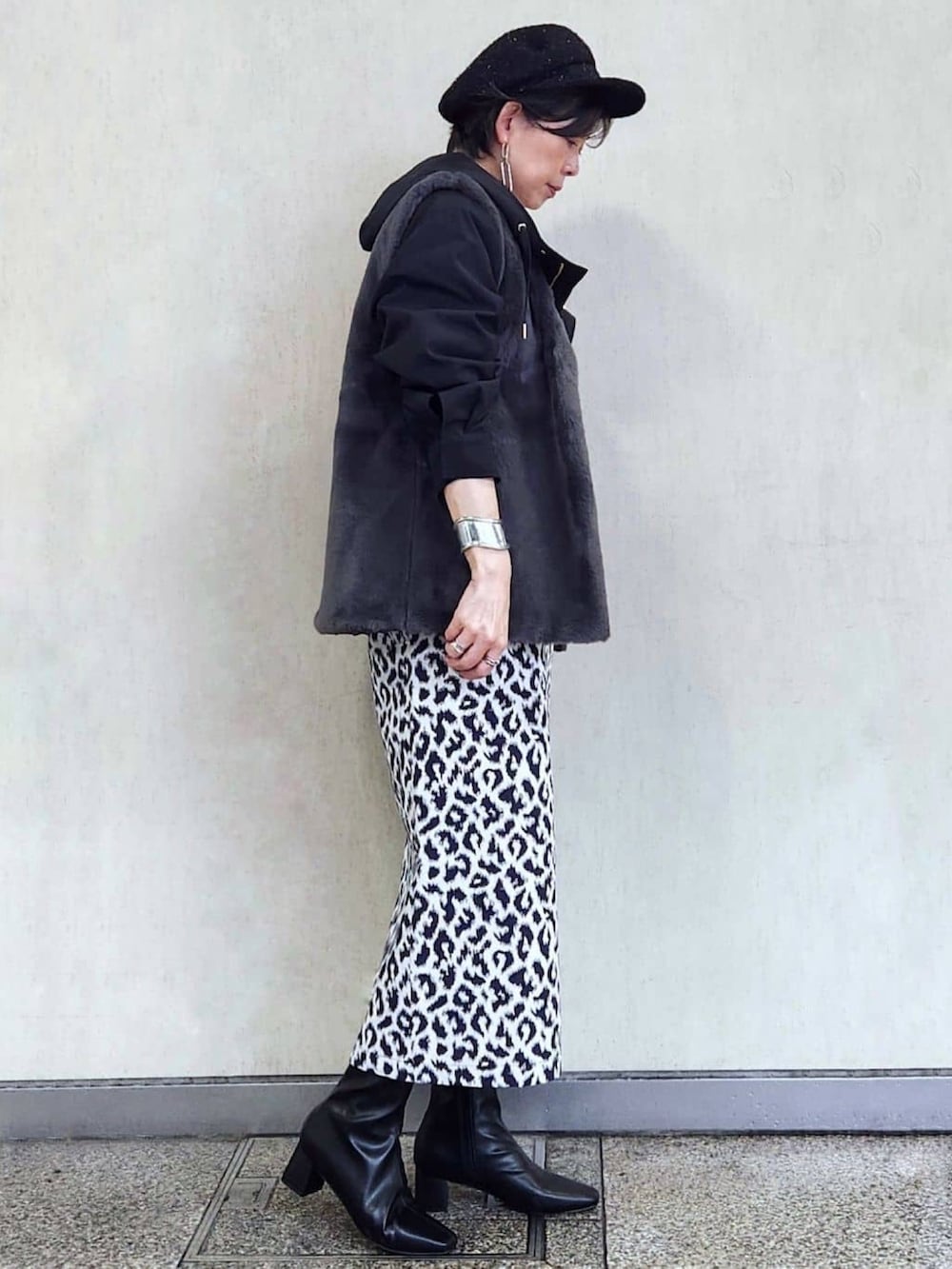 ブラック系のブルゾン、ブルー系のスカート、ブラック系のブーツを着用したレディースの秋コーディネートの4枚目の写真