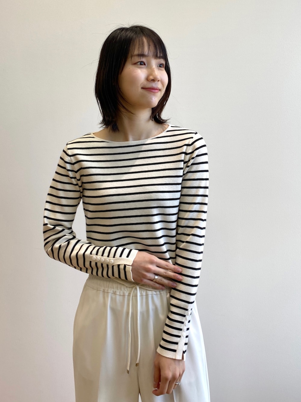 ホワイト系のその他パンツ、ホワイト系のその他シューズ、ブラック系のショルダーバッグを着用したレディースの春コーディネートの4枚目の写真