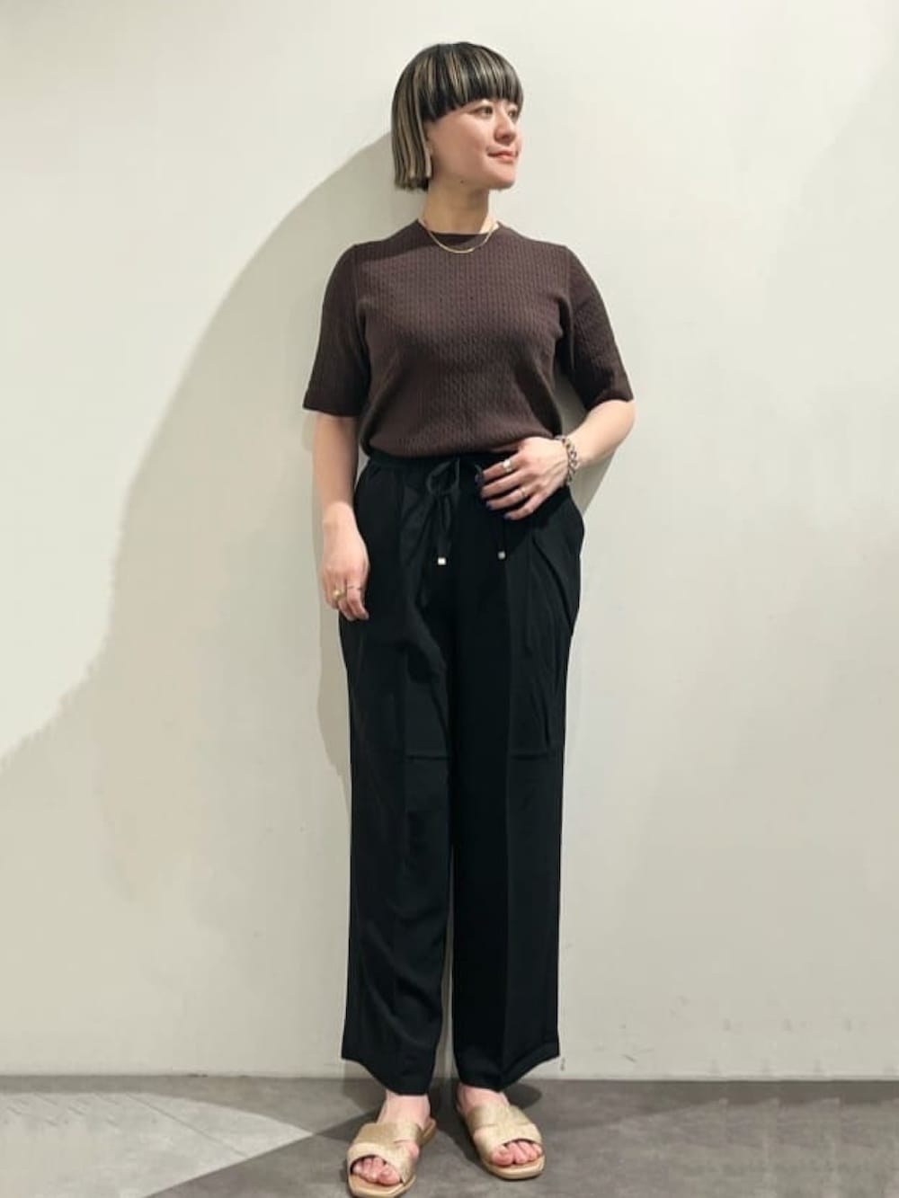 ベージュ系のノーカラージャケット、ブラウン系のニット/セーター、ブラック系のトートバッグを着用したレディースの春コーディネートの4枚目の写真