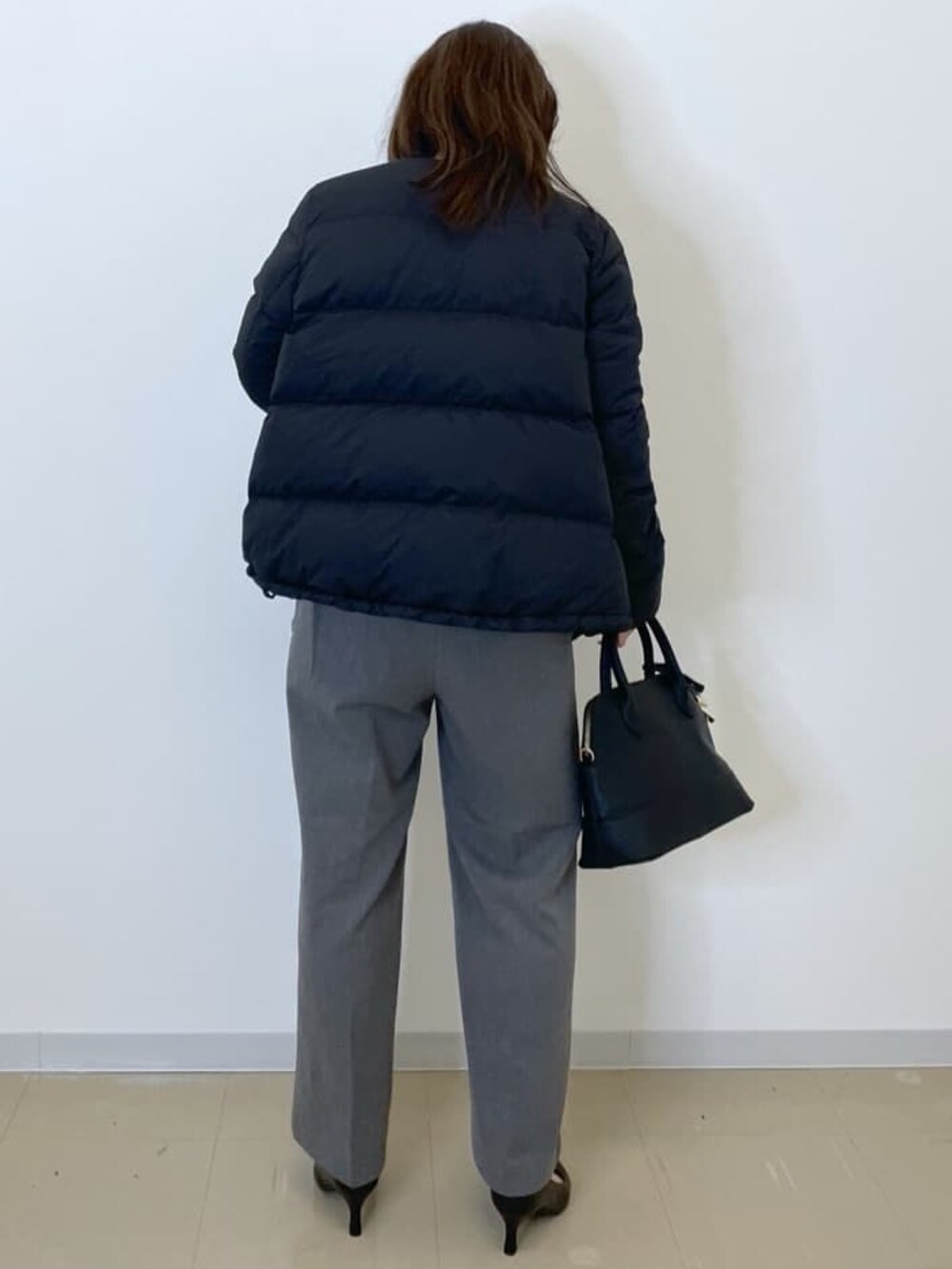 ブラック系のダウンジャケット/コート、グレー系のニット/セーター、グレー系のその他パンツを着用したレディースの秋コーディネートの5枚目の写真