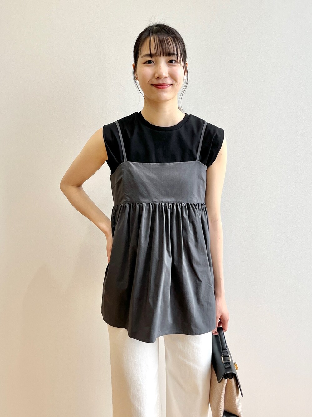 ブラック系のショルダーバッグ、ホワイト系のデニムパンツ、ブラック系のサンダルを着用したレディースの夏コーディネートの4枚目の写真