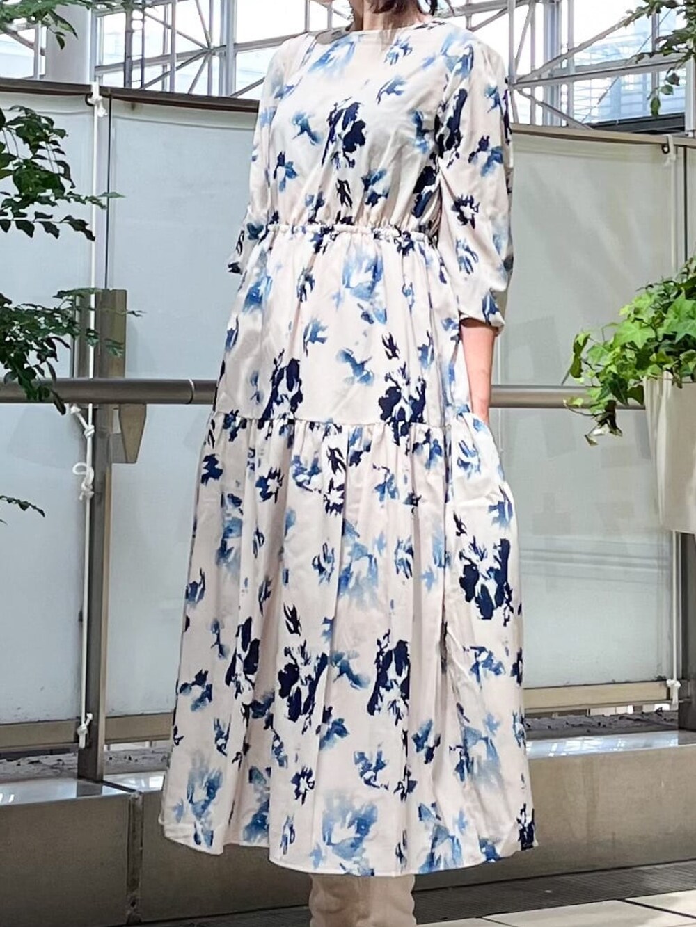 ベージュ系のワンピース、ホワイト系のショルダーバッグ、ホワイト系のブーツを着用したレディースの秋コーディネートの2枚目の写真