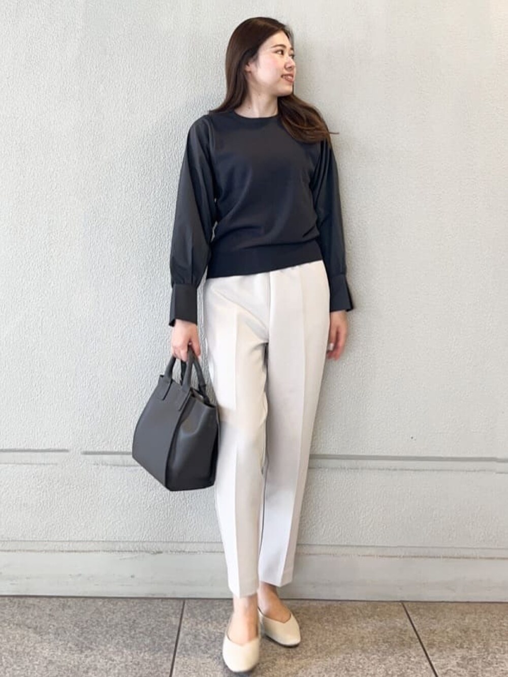 グレー系のニット/セーター、ホワイト系のその他パンツ、グレー系のトートバッグを着用したレディースの秋コーディネートの2枚目の写真