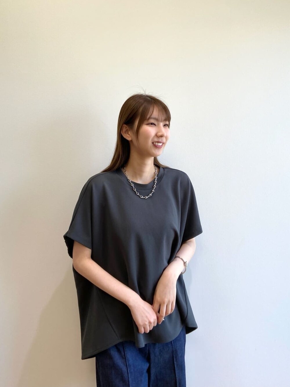 グレー系のTシャツ/カットソー、ブルー系のデニムパンツ、ブラック系のサンダルを着用したレディースの春コーディネートの8枚目の写真
