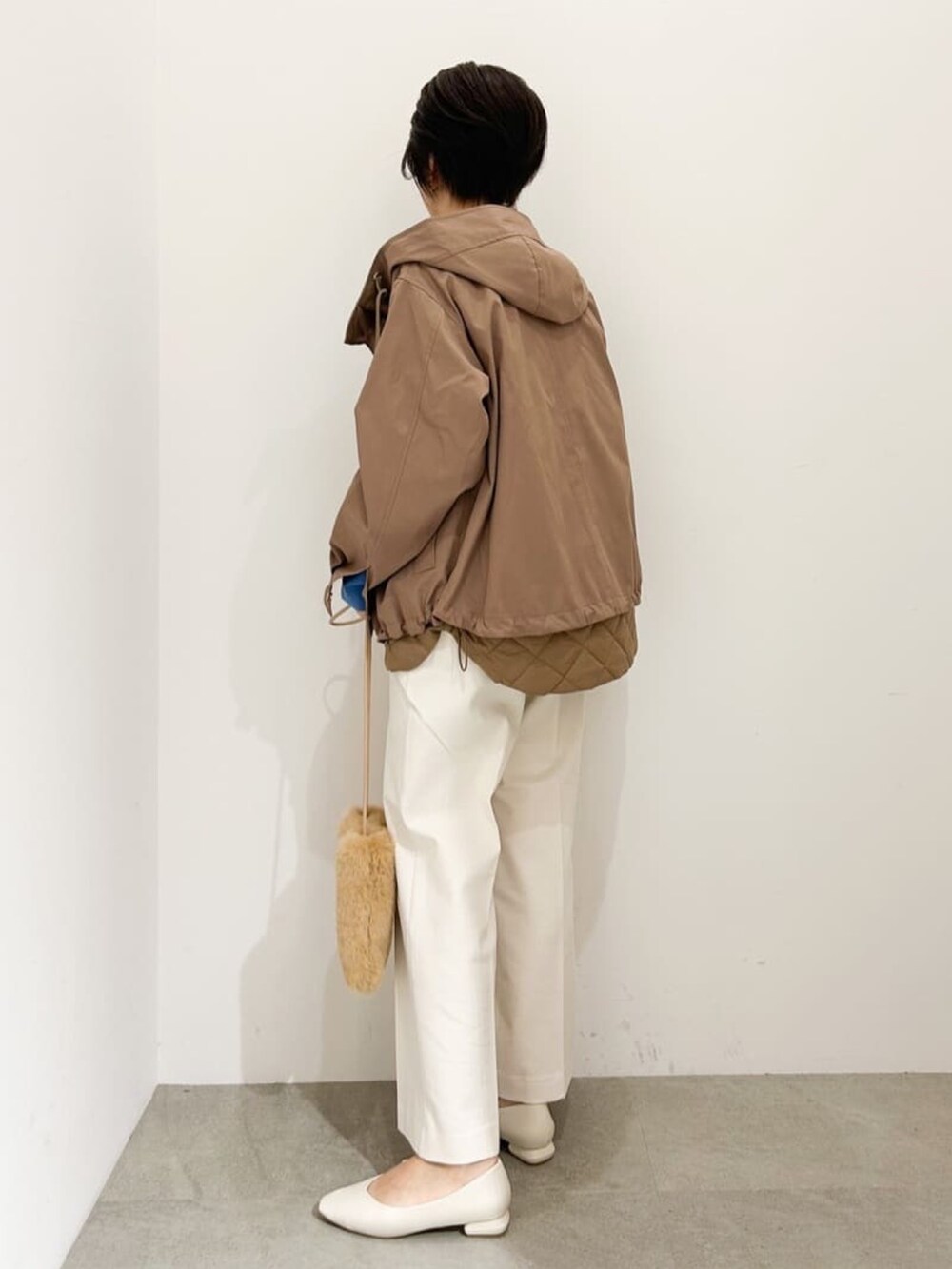 ブラウン系のブルゾン、ブルー系のニット/セーター、ホワイト系のその他パンツを着用したレディースの秋コーディネートの3枚目の写真