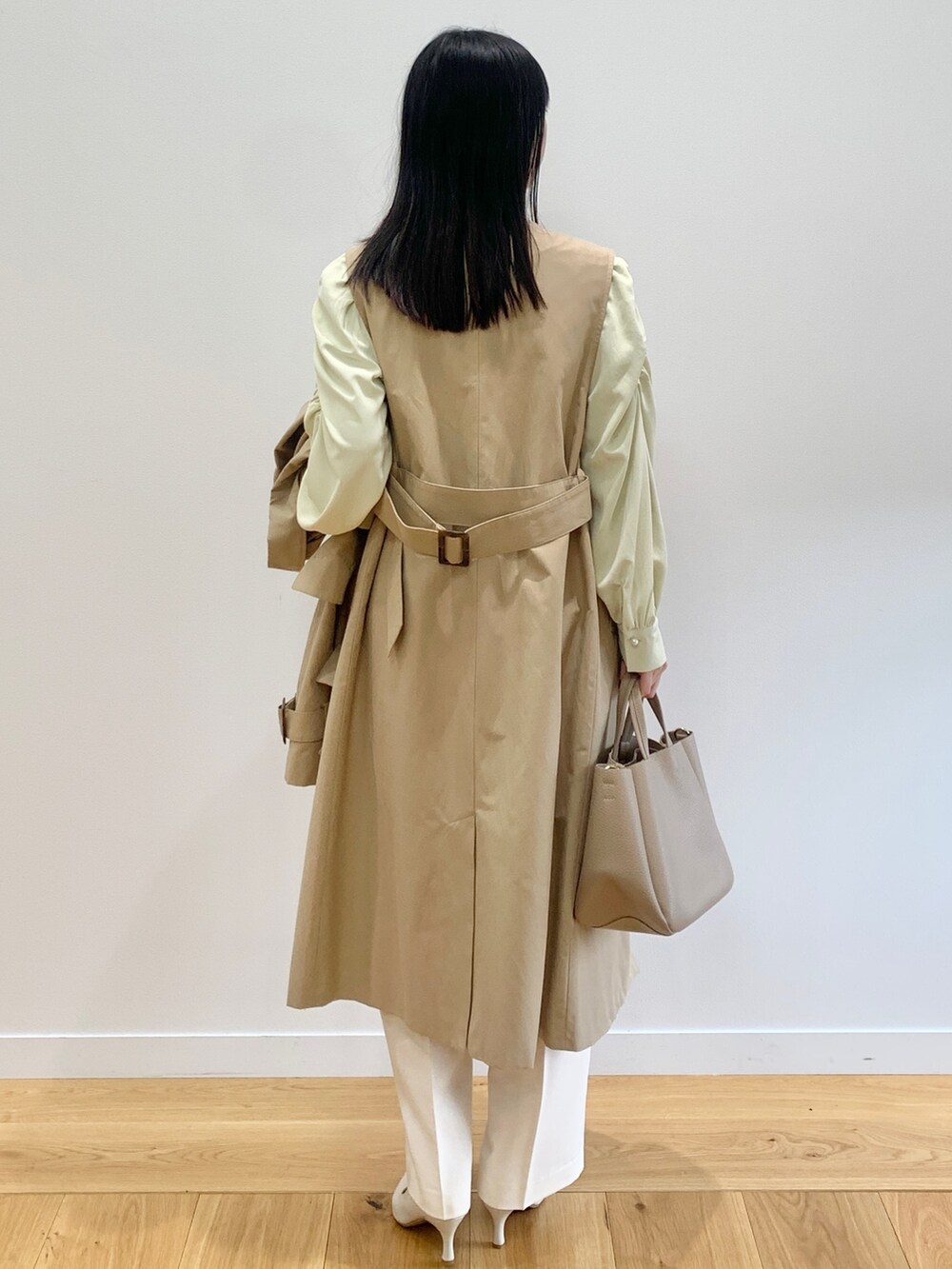 ベージュ系のトレンチコート、イエロー系のシャツ/ブラウス、ホワイト系のその他パンツを着用したレディースの春コーディネートの3枚目の写真