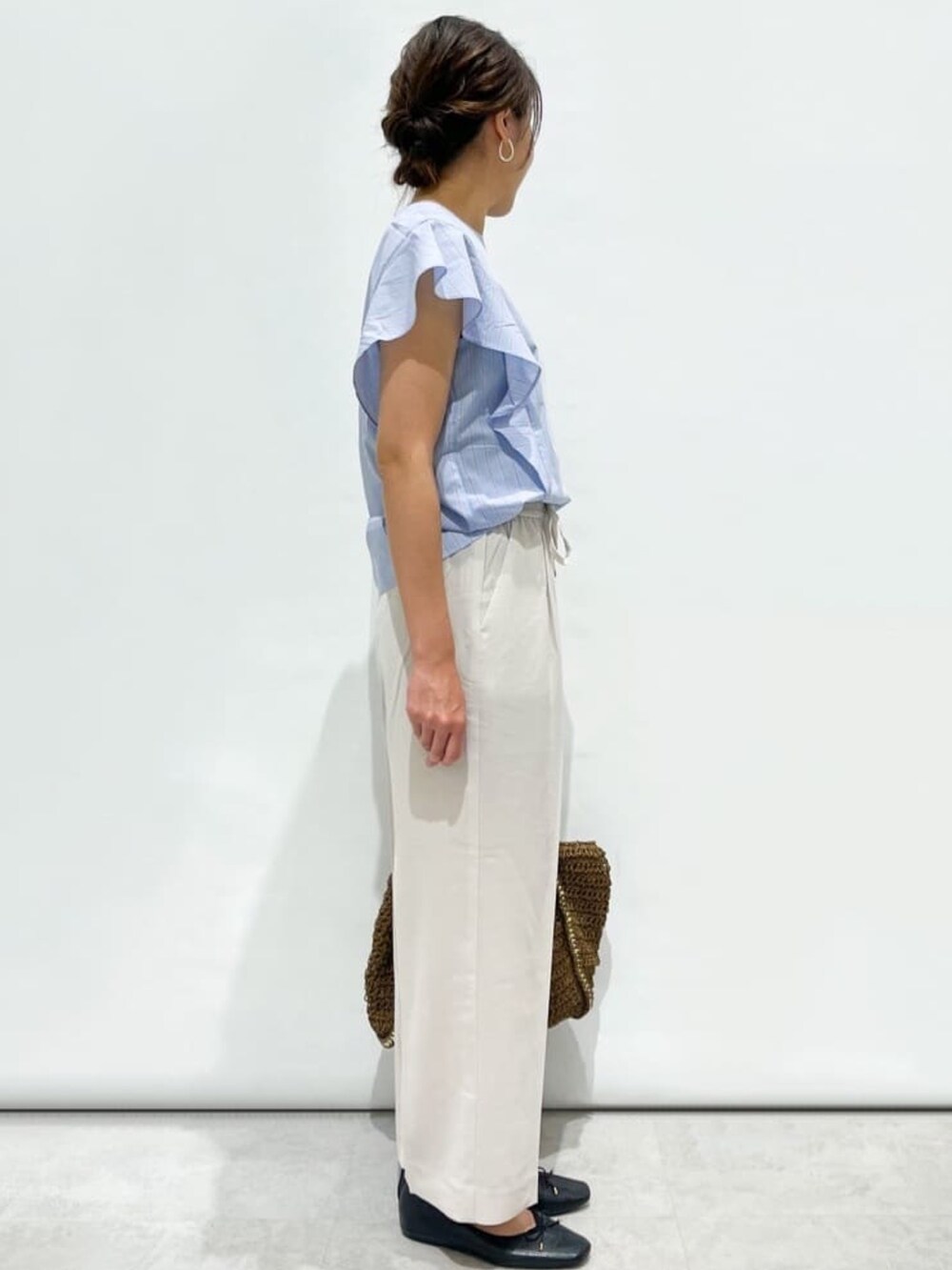 ブルー系のシャツ/ブラウス、グレー系のその他パンツ、ブラウン系のトートバッグを着用したレディースの夏コーディネートの2枚目の写真