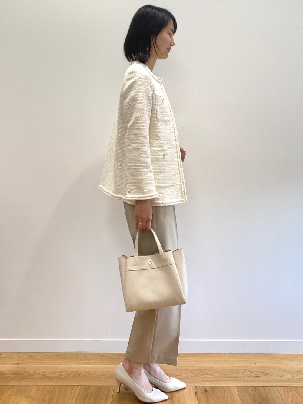 ホワイト系のノーカラージャケット、ベージュ系のその他パンツ、ホワイト系のパンプスを着用したレディースの冬コーディネートの2枚目の写真