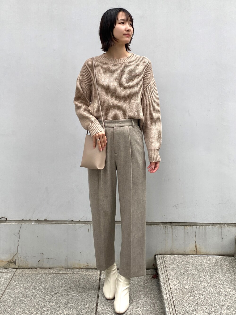 ベージュ系のチェスターコート、ベージュ系のその他パンツ、ホワイト系のブーツを着用したレディースの冬コーディネートの4枚目の写真