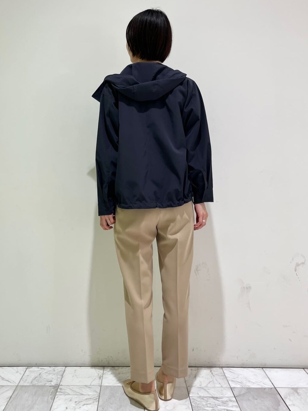 ベージュ系のその他パンツ、ゴールド系のその他シューズ、ホワイト系のニット/セーターを着用したレディースの春コーディネートの3枚目の写真