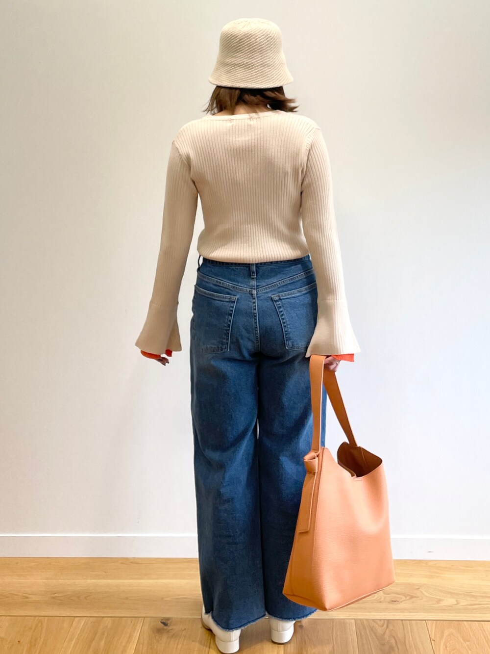 ベージュ系のニット/セーター、ブルー系のデニムパンツ、ホワイト系のその他シューズを着用したレディースの冬コーディネートの3枚目の写真