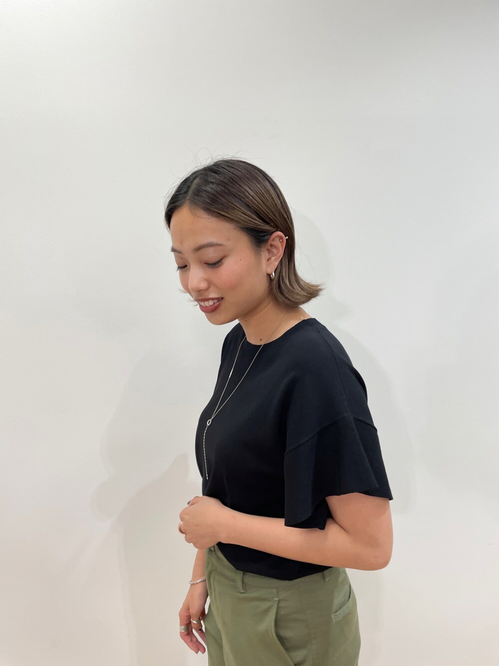 ブラック系のニット/セーター、グリーン系のその他パンツ、ベージュ系のパンプスを着用したレディースの夏コーディネートの4枚目の写真