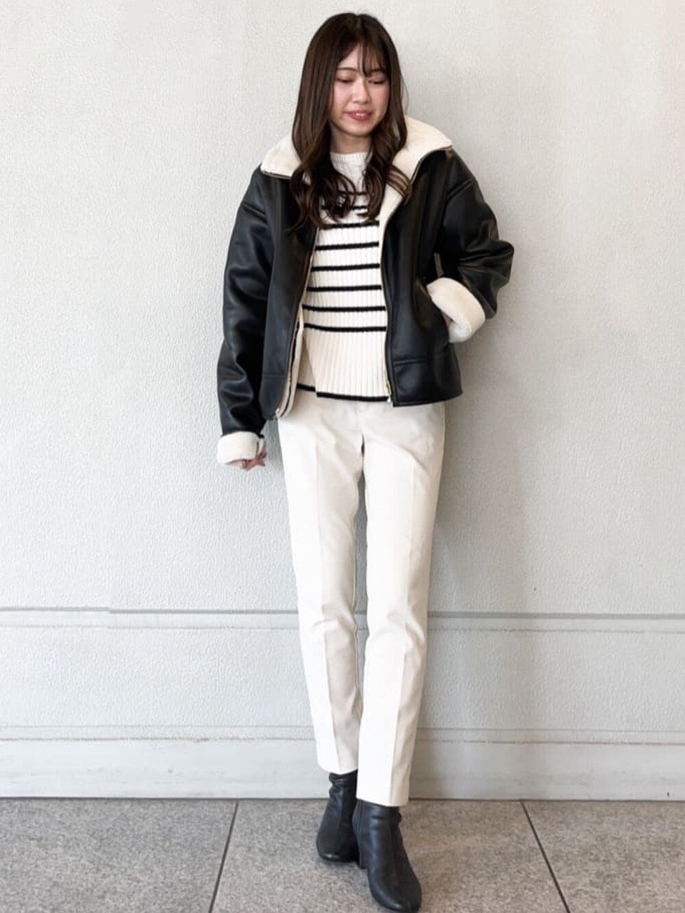 ブラック系のブルゾン、ホワイト系のその他パンツ、ホワイト系のニット/セーターを着用したレディースの冬コーディネートの2枚目の写真