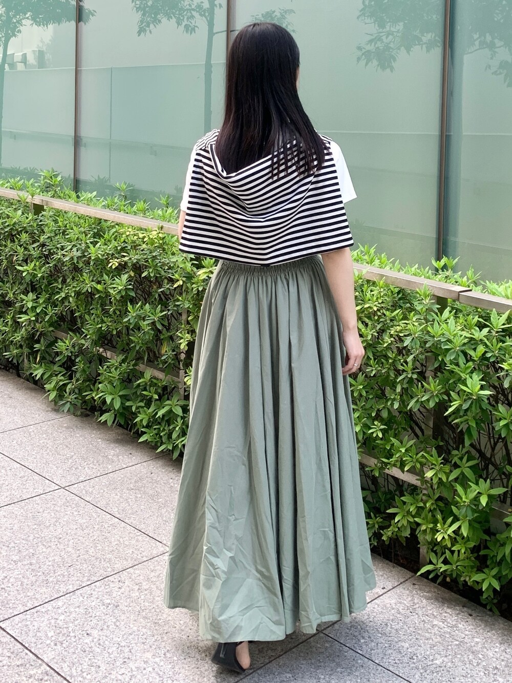 ホワイト系のTシャツ/カットソー、ホワイト系のカーディガン/ボレロ、グリーン系のスカートを着用したレディースの春コーディネートの3枚目の写真