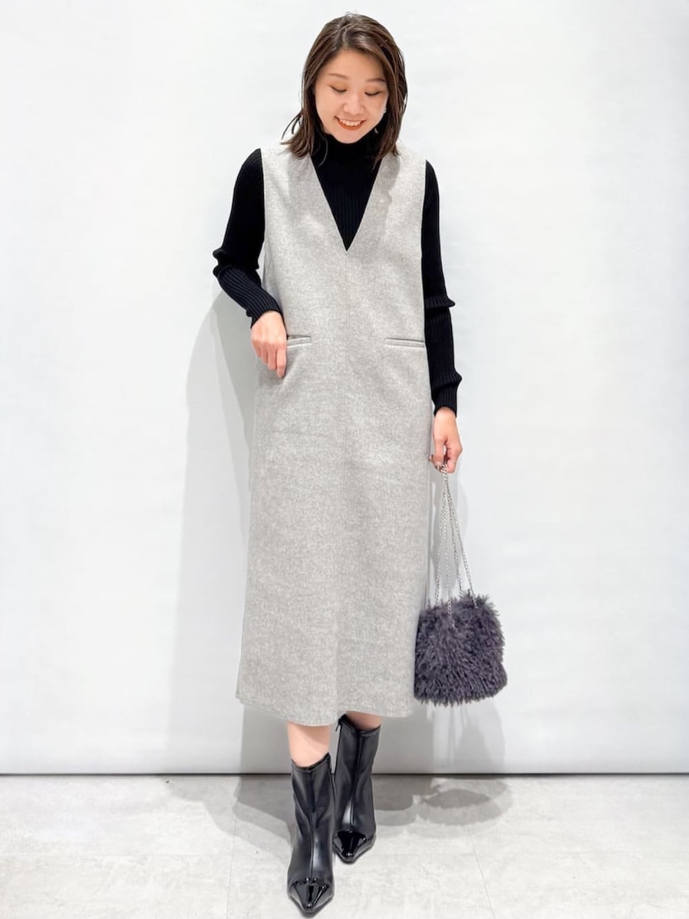 ブラック系のニット/セーター、グレー系のピーコート、グレー系のショルダーバッグを着用したレディースの秋コーディネートの6枚目の写真