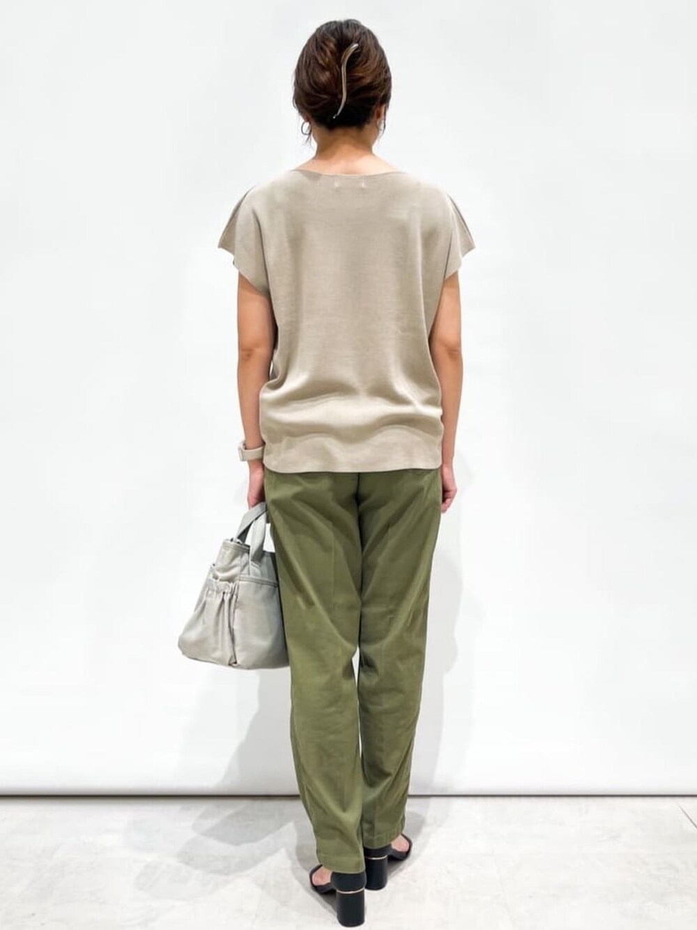 ベージュ系のニット/セーター、グリーン系のその他パンツ、ブラック系のサンダルを着用したレディースの夏コーディネートの3枚目の写真