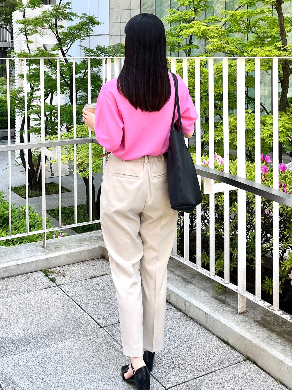 ピンク系のニット/セーター、ベージュ系のその他パンツ、ブラック系のトートバッグを着用したレディースの春コーディネートの3枚目の写真