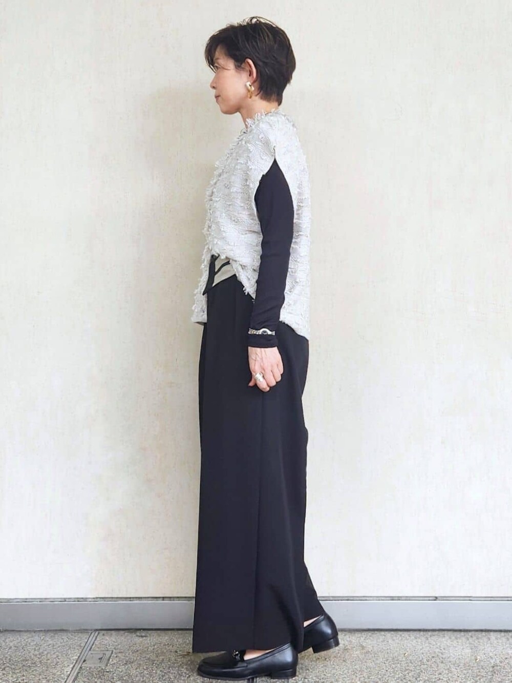 グレー系のニット/セーター、ブラック系のTシャツ/カットソー、ブラック系のその他パンツを着用したレディースの秋コーディネートの3枚目の写真