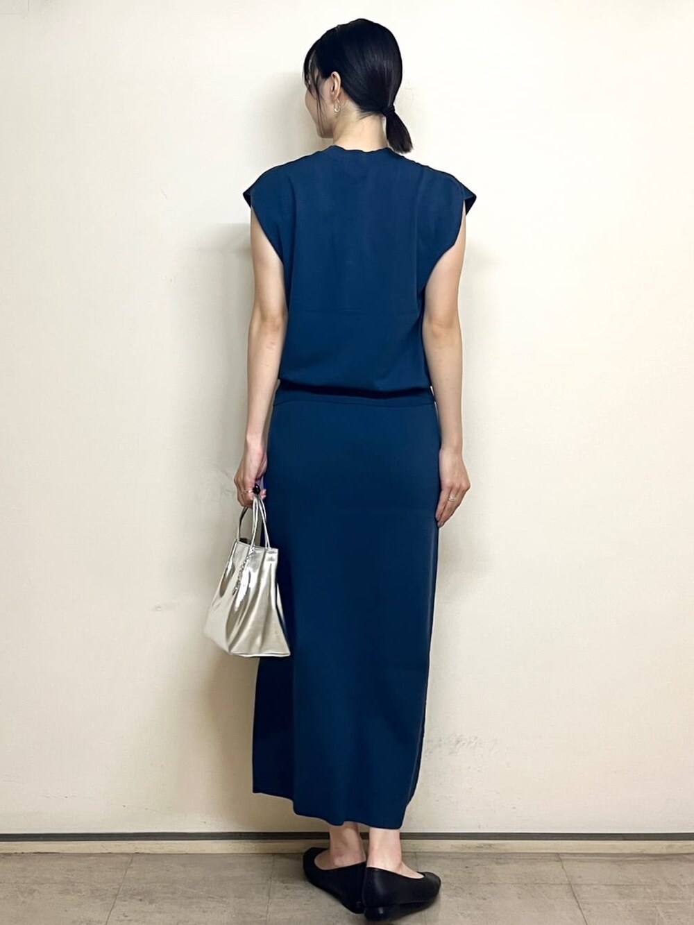 ブルー系のベスト、ブルー系のスカート、シルバー系のトートバッグを着用したレディースの夏コーディネートの4枚目の写真