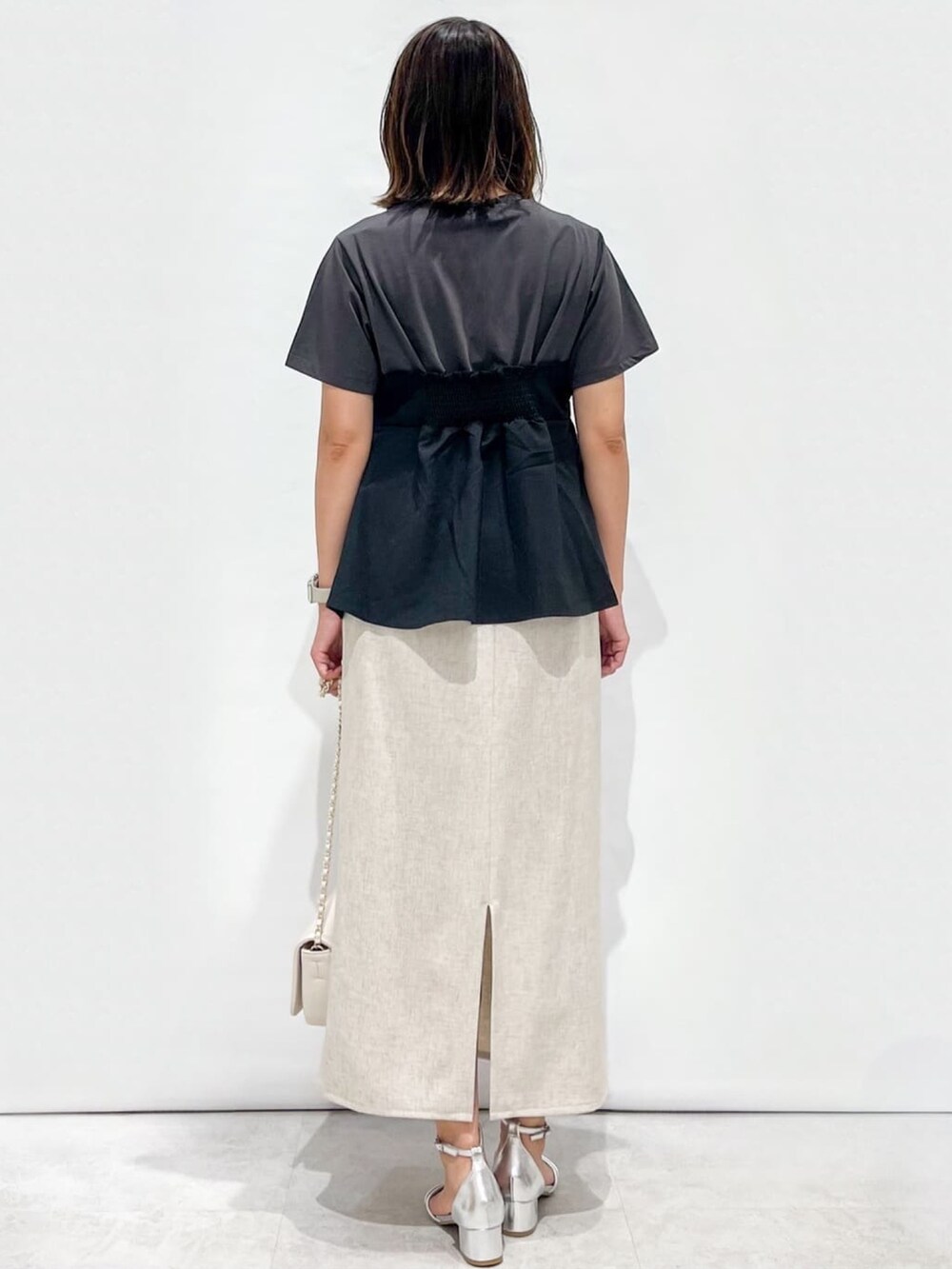 ブラック系のTシャツ/カットソー、ベージュ系のスカート、ホワイト系のショルダーバッグを着用したレディースの夏コーディネートの7枚目の写真