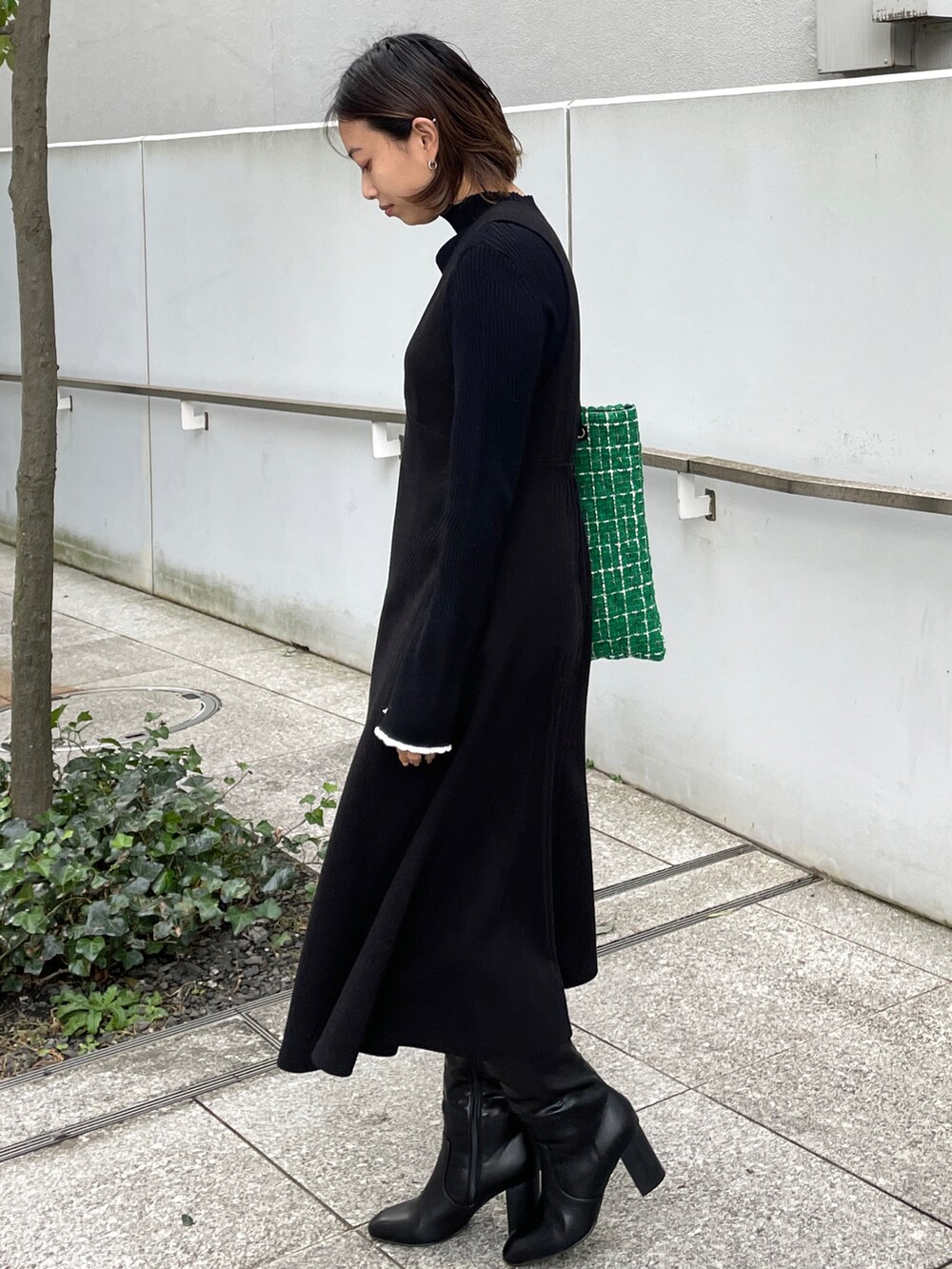 ブラック系のニット/セーター、ブラック系のスカート、グリーン系のトートバッグを着用したレディースの冬コーディネートの2枚目の写真