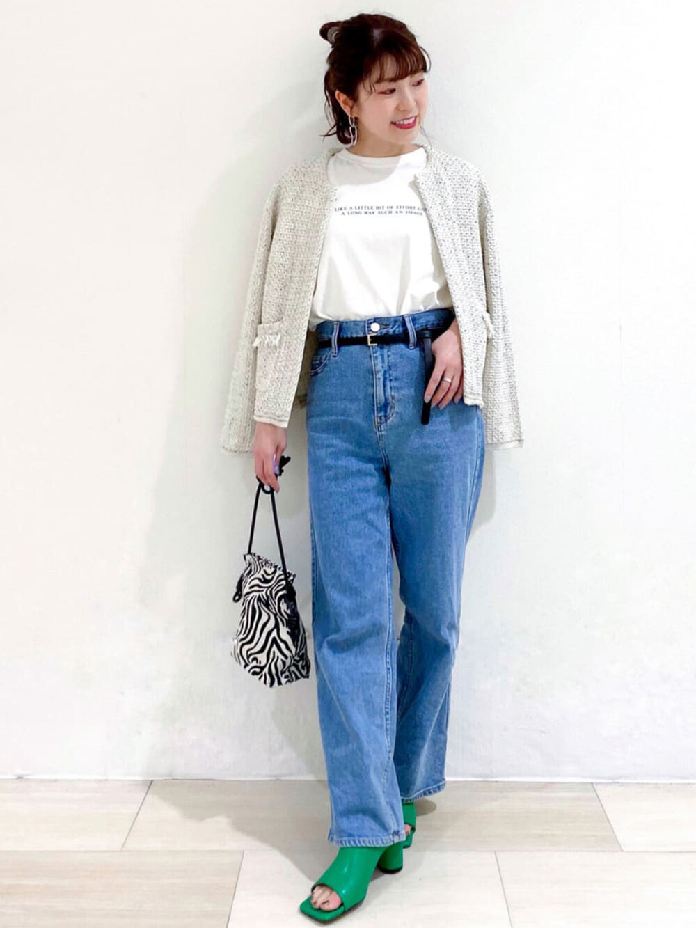 ホワイト系のカーディガン/ボレロ、ホワイト系のTシャツ/カットソー、ブルー系のデニムパンツを着用したレディースの春コーディネートの2枚目の写真