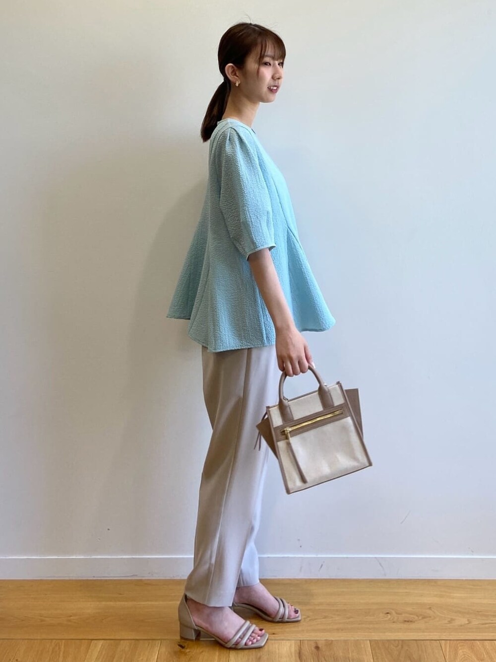 ブルー系のシャツ/ブラウス、ベージュ系のハンドバッグ、グレー系のその他パンツを着用したレディースの春コーディネートの3枚目の写真