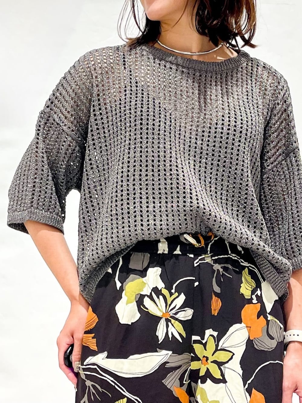 シルバー系のニット/セーター、ブラウン系のその他パンツ、ブラック系のショルダーバッグを着用したレディースの夏コーディネートの7枚目の写真