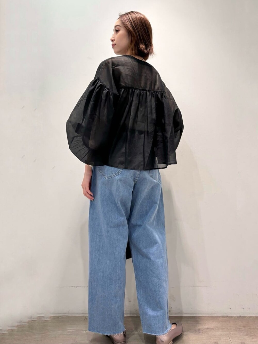 ブラック系のシャツ/ブラウス、シルバー系のパンプス、ブルー系のデニムパンツを着用したレディースの夏コーディネートの4枚目の写真