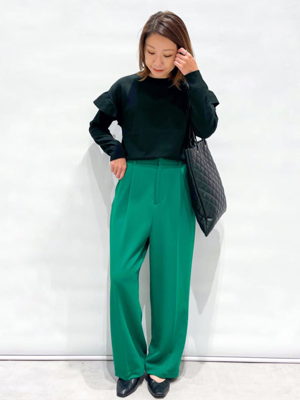 ベージュ系のテーラードジャケット、ブラック系のニット/セーター、ブラック系のパンプスを着用したレディースの秋コーディネートの3枚目の写真