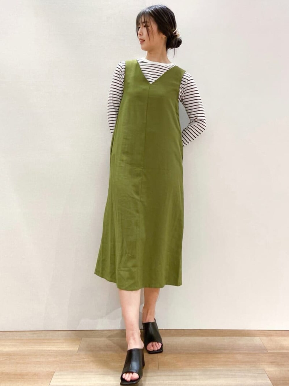 グリーン系のスカート、ホワイト系のTシャツ/カットソー、ブラック系のトートバッグを着用したレディースの春コーディネートの3枚目の写真