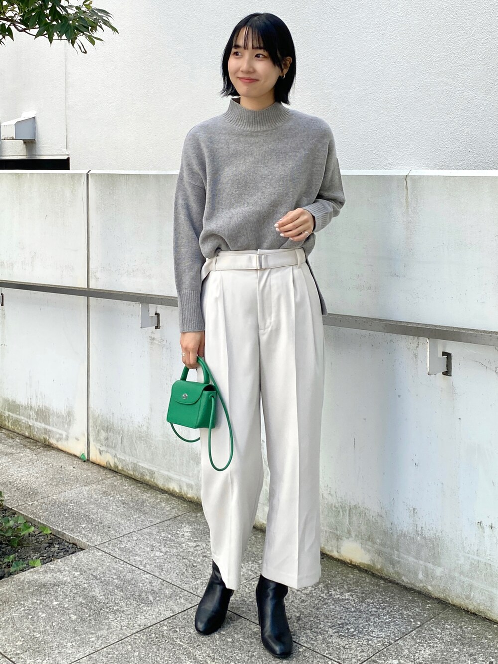 ブラック系のノーカラーコート、グレー系のその他パンツ、グレー系のニット/セーターを着用したレディースの冬コーディネートの3枚目の写真