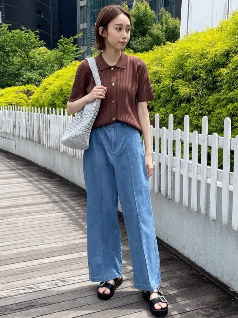 ブラウン系のニット/セーター、ブルー系のデニムパンツ、シルバー系のトートバッグを着用したレディースの春コーディネートの3枚目の写真