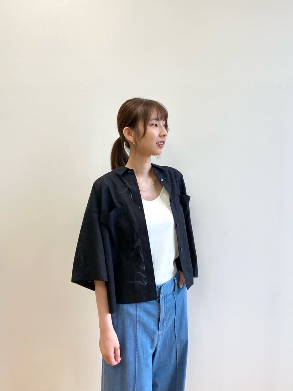 ブルー系のデニムパンツ、ブラック系のサンダル、ブラック系のシャツ/ブラウスを着用したレディースの夏コーディネートの6枚目の写真