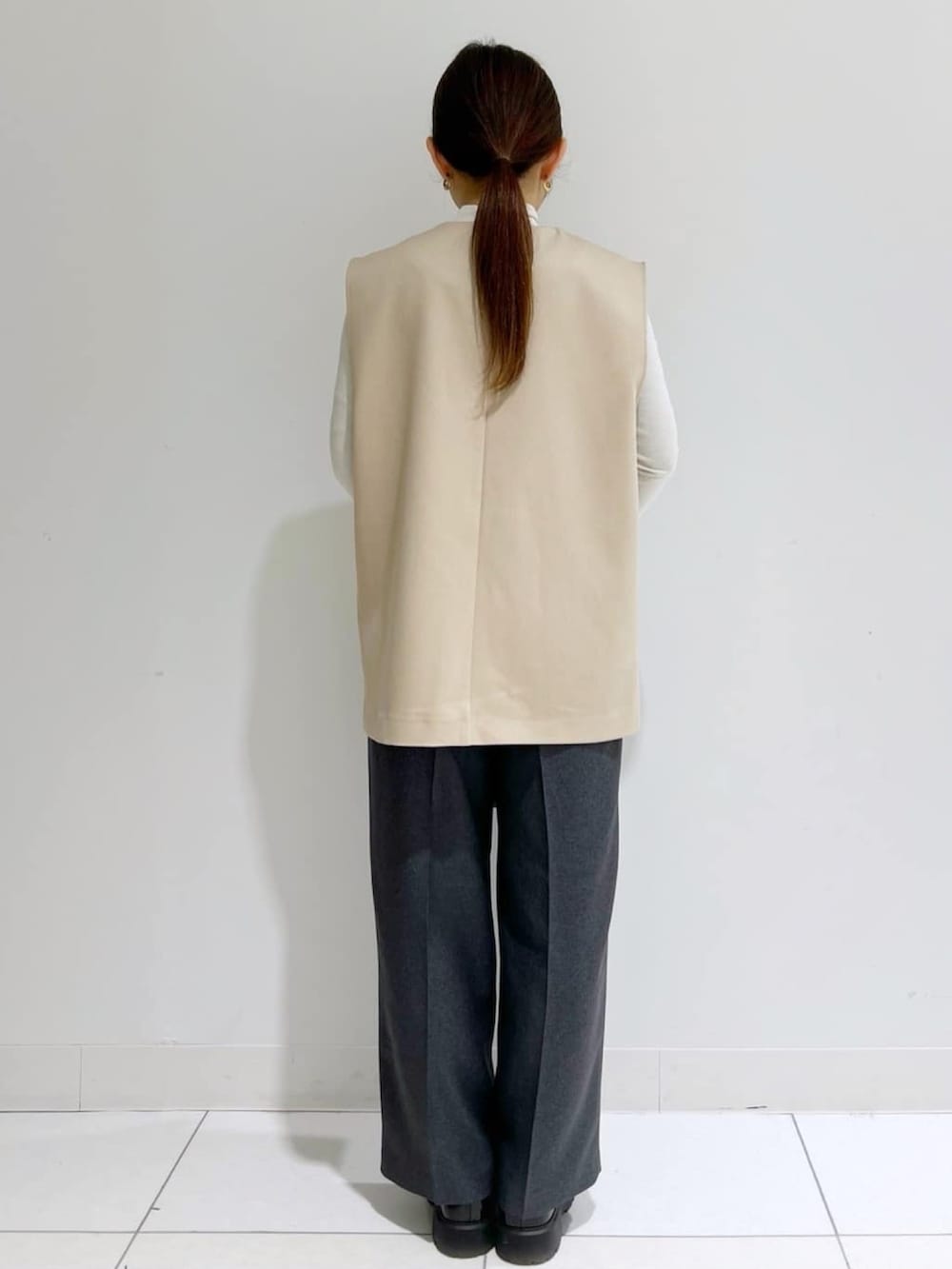 ベージュ系のベスト、グレー系のその他パンツ、ブラック系のパンプスを着用したレディースの春コーディネートの2枚目の写真