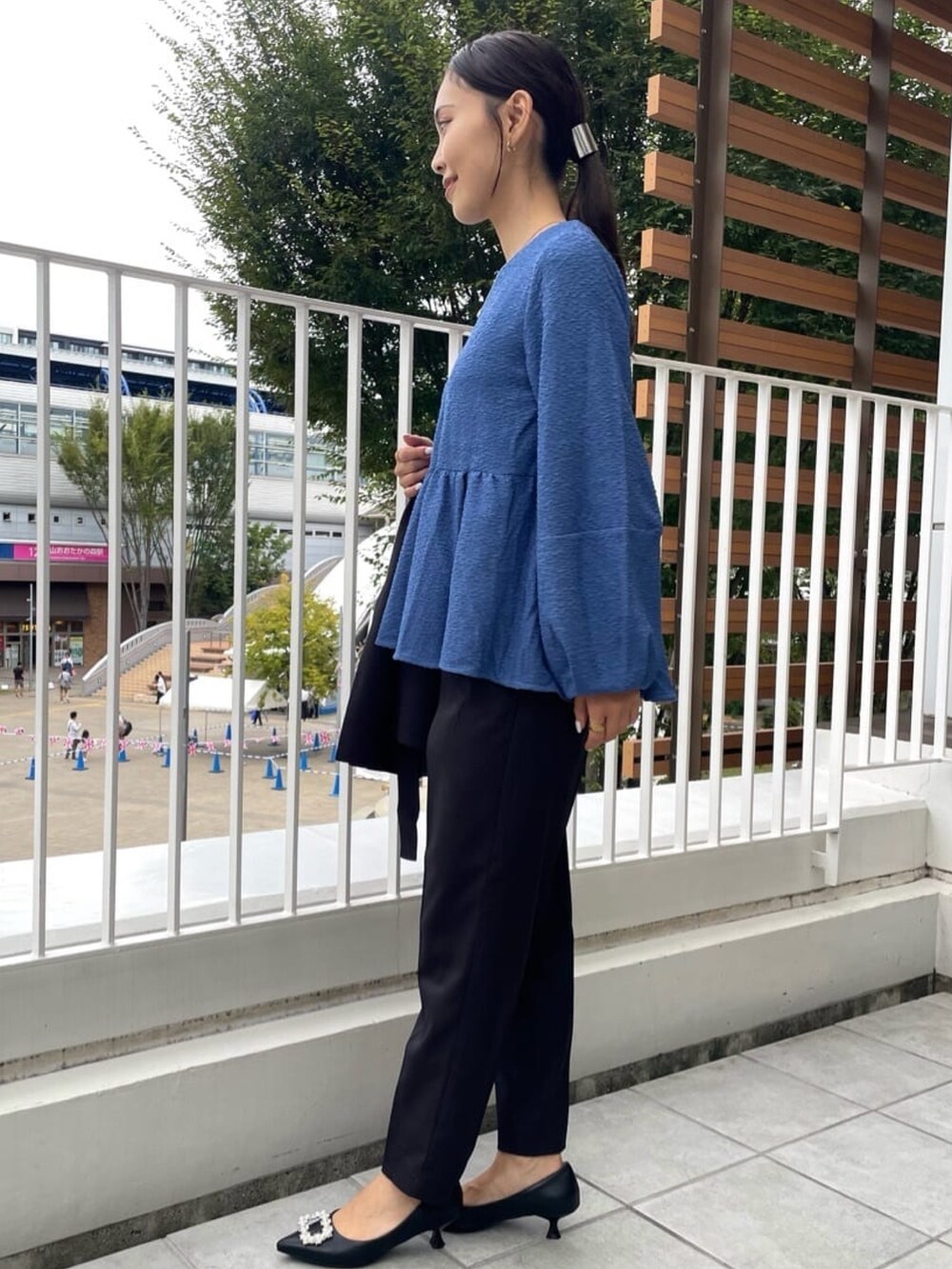 シルバー系のトートバッグ、ブラック系のその他パンツ、ブラック系のパンプスを着用したレディースの秋コーディネートの4枚目の写真