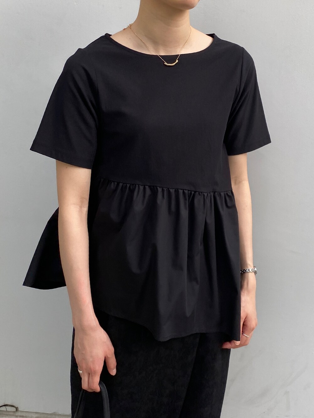 ブラック系のTシャツ/カットソー、ブラック系のスカート、ブラック系のトートバッグを着用したレディースの春コーディネートの2枚目の写真