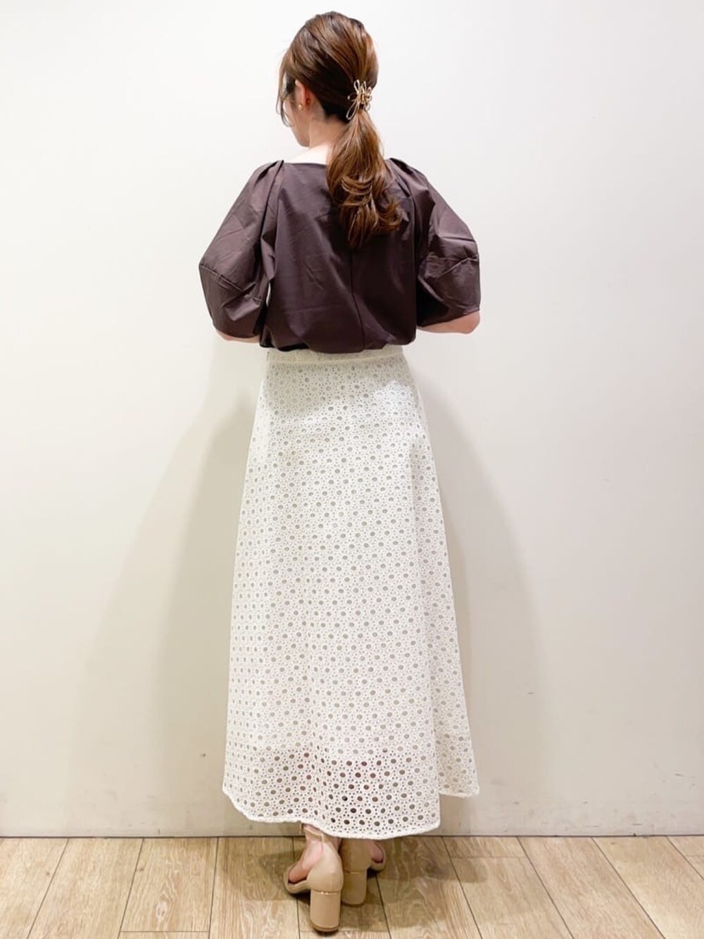 ブラウン系のTシャツ/カットソー、ホワイト系のスカート、ベージュ系のトートバッグを着用したレディースの春コーディネートの3枚目の写真