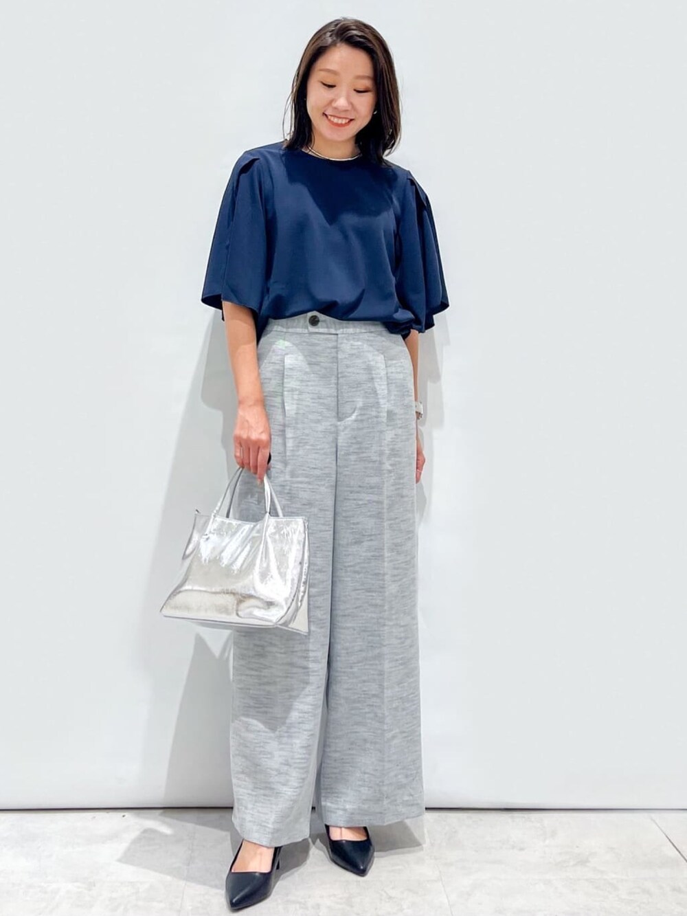 ブラック系のその他パンツ、ブラック系のパンプス、シルバー系のトートバッグを着用したレディースの夏コーディネートの4枚目の写真