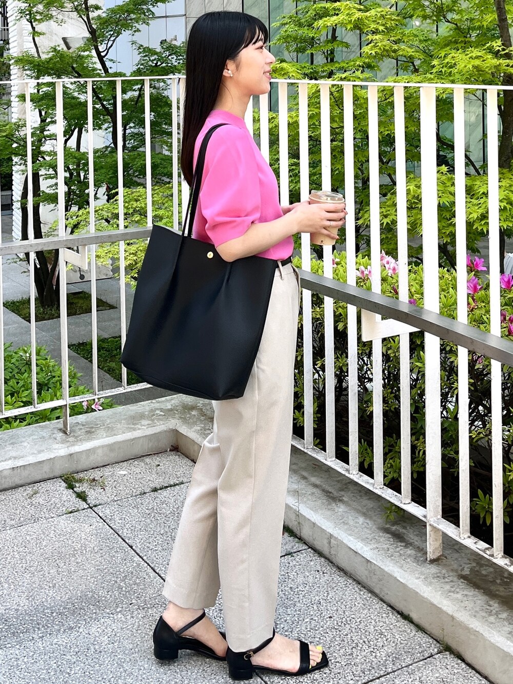 ピンク系のニット/セーター、ベージュ系のその他パンツ、ブラック系のトートバッグを着用したレディースの春コーディネートの2枚目の写真