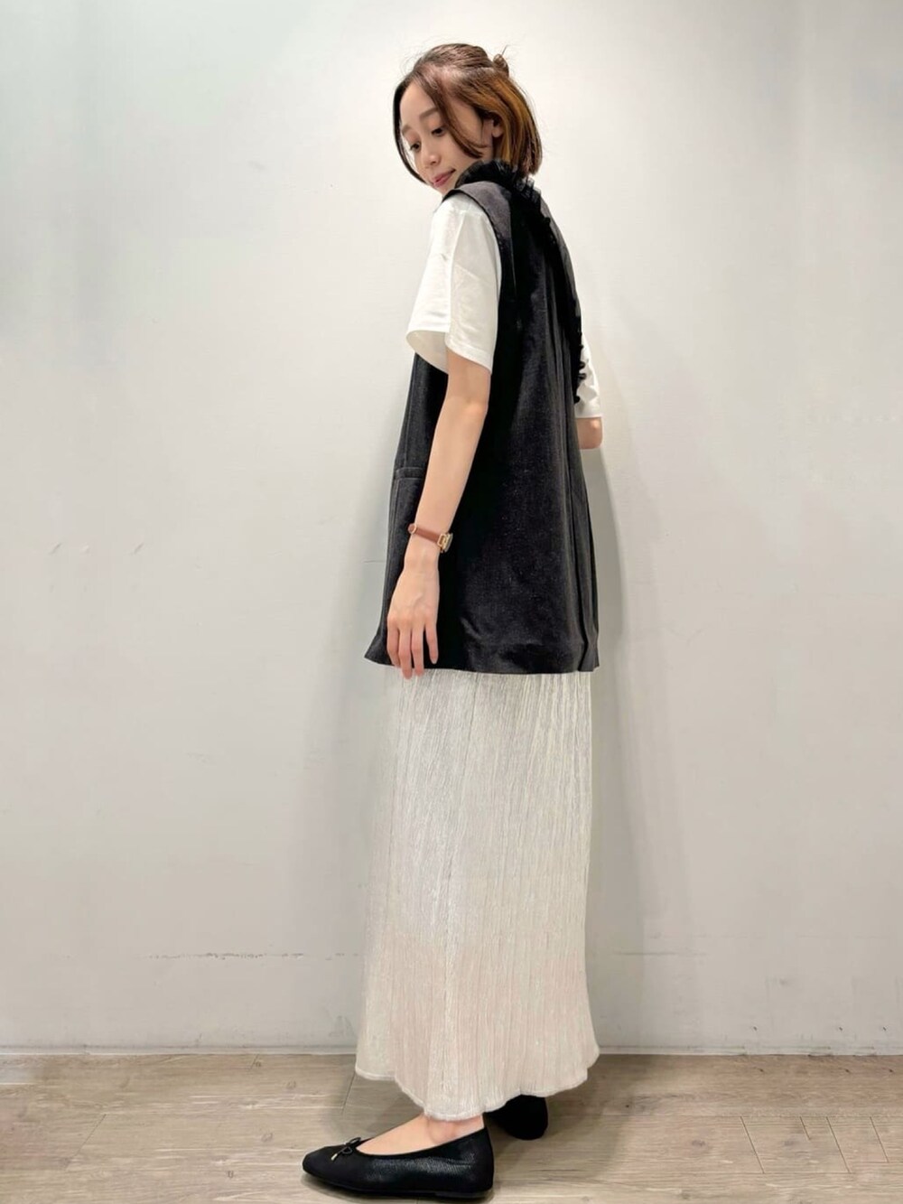 シルバー系のスカート、グレー系のベスト、ホワイト系のTシャツ/カットソーを着用したレディースの夏コーディネートの5枚目の写真