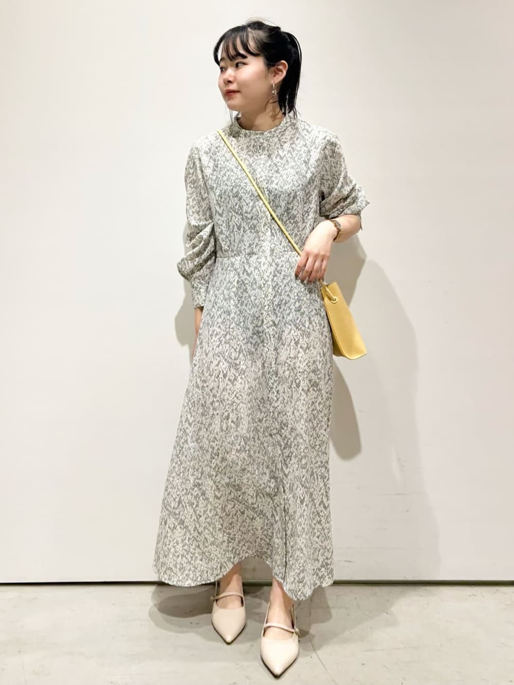 ベージュ系のブルゾン、ホワイト系のワンピース、イエロー系のショルダーバッグを着用したレディースの春コーディネートの3枚目の写真