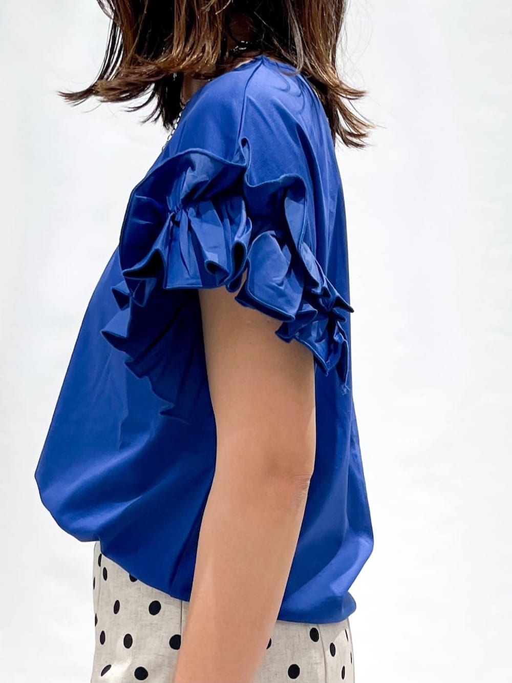 ベージュ系のスカート、ブラック系のショルダーバッグ、シルバー系のサンダルを着用したレディースの夏コーディネートの8枚目の写真