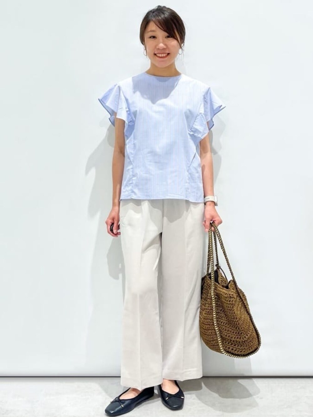 ブルー系のシャツ/ブラウス、グレー系のその他パンツ、ブラウン系のトートバッグを着用したレディースの夏コーディネートの3枚目の写真