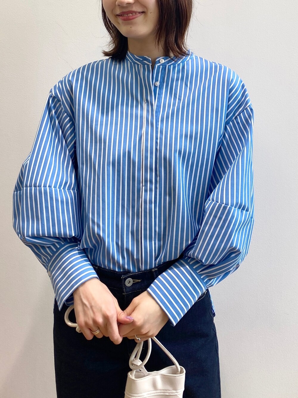 ブラウン系のサンダル、ブルー系のシャツ/ブラウス、ホワイト系のニット/セーターを着用したレディースの春コーディネートの4枚目の写真