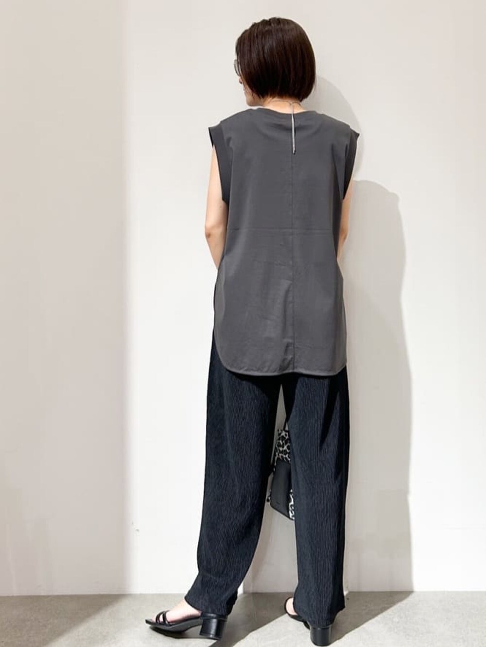 ブラック系のその他パンツ、ホワイト系のショルダーバッグ、ブラック系のサンダルを着用したレディースの夏コーディネートの3枚目の写真